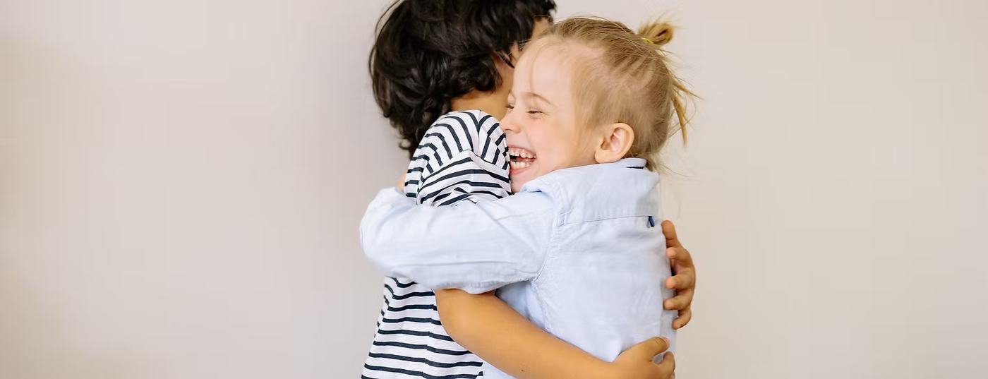 Zwei Kinder umarmen sich